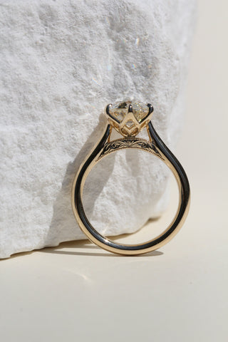 Gold ring with a diamond on a textured white surface