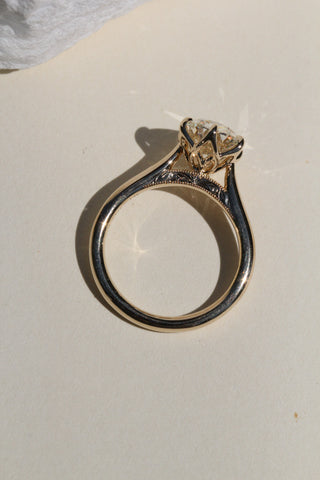 Gold ring with a diamond on a light background
